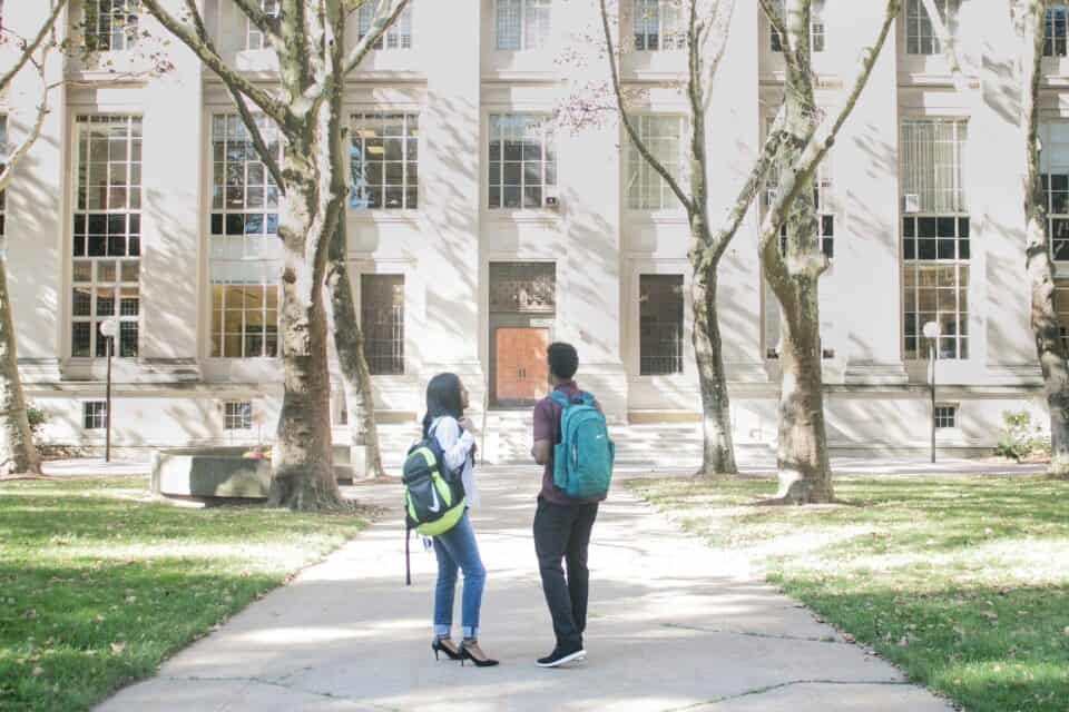 Two students standing outside campus building.